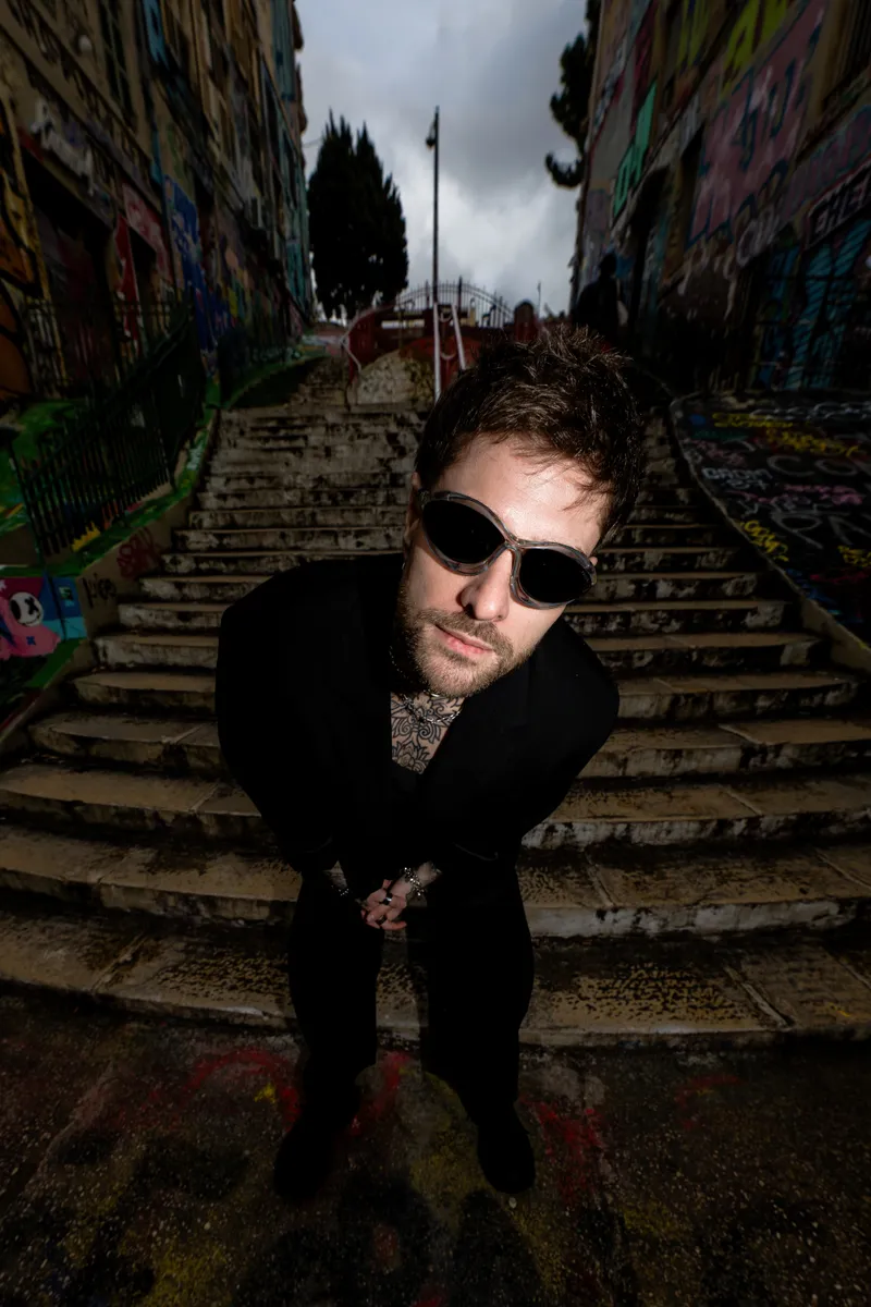 Rafael Cerato on a graffiti-covered outdoor staircase